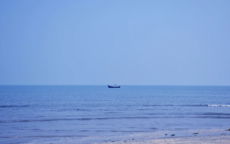 the lone boat sails across the open ocean