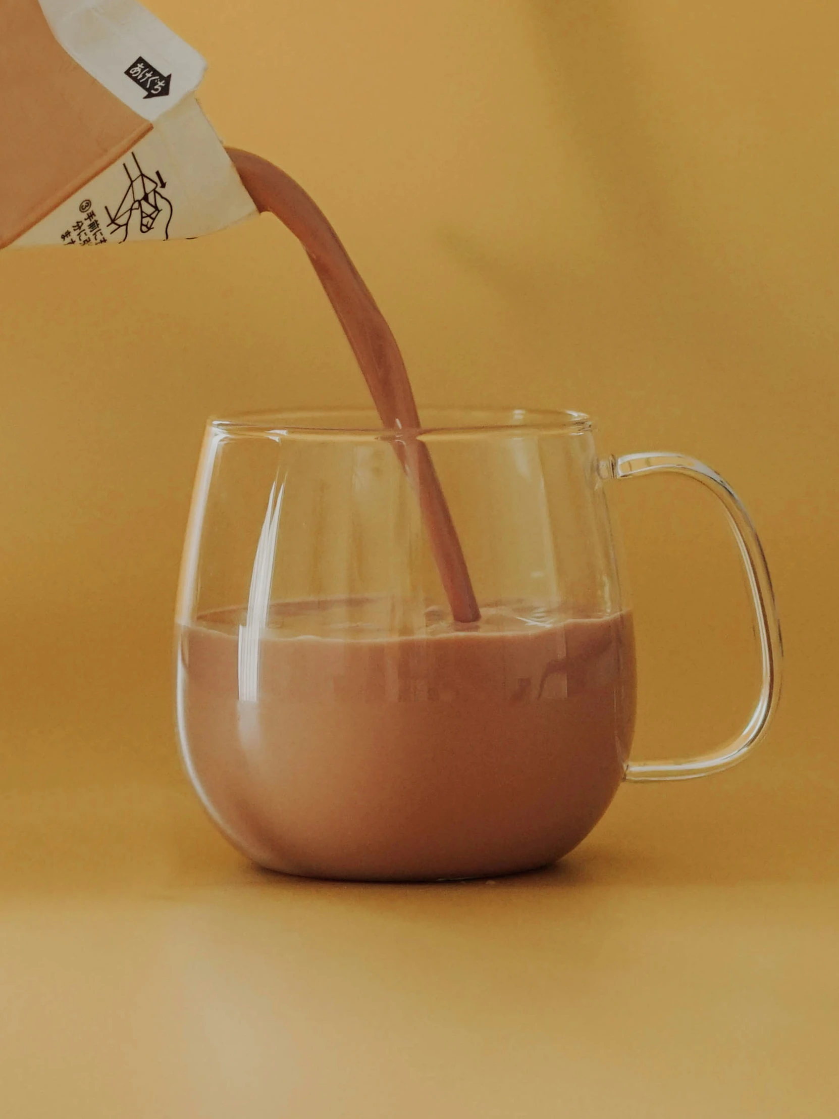 a glass pitcher filled with coffee being poured into the pitcher