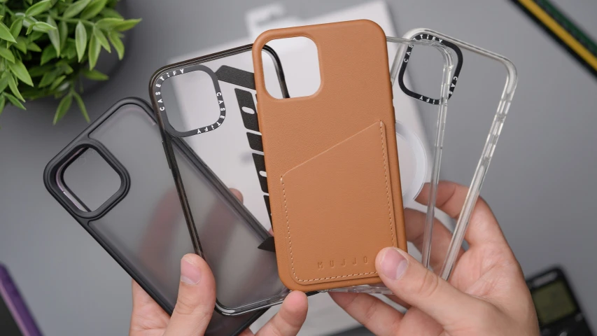 a man holding three cell phone cases with card slot