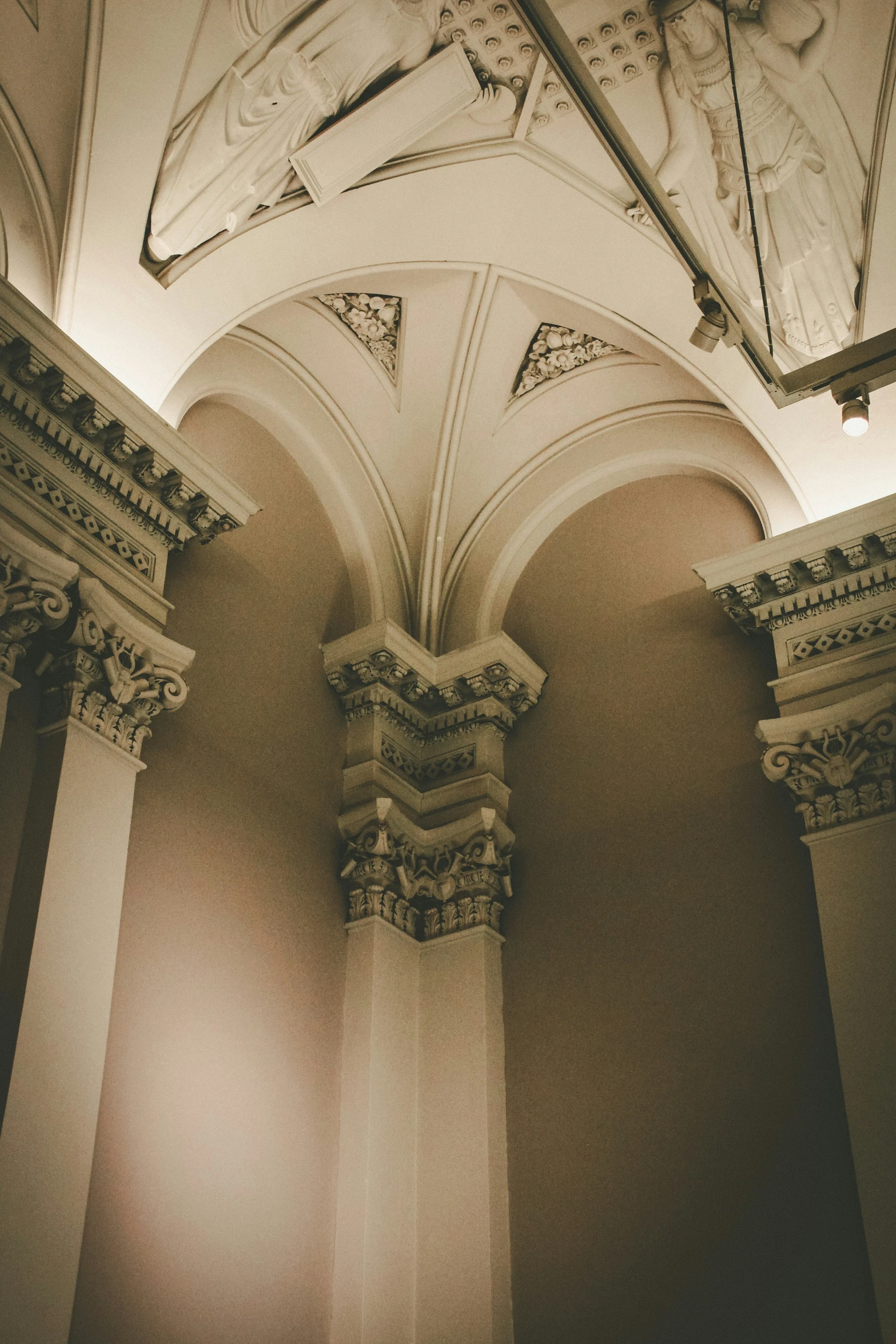 a building with columns and a light coming from the ceiling