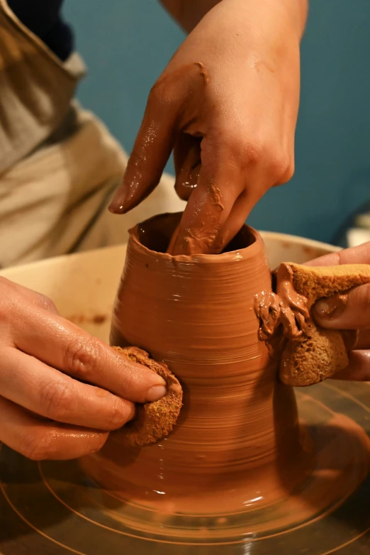 a person that is creating soing out of clay