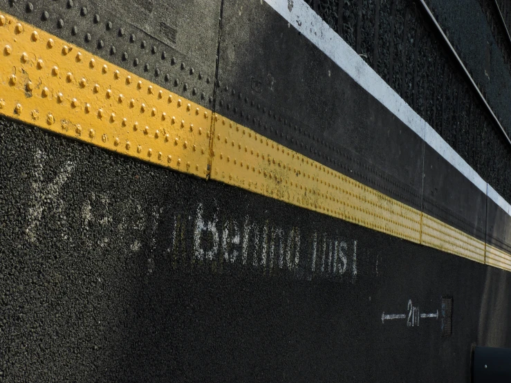 a train sits at the side of a yellow line
