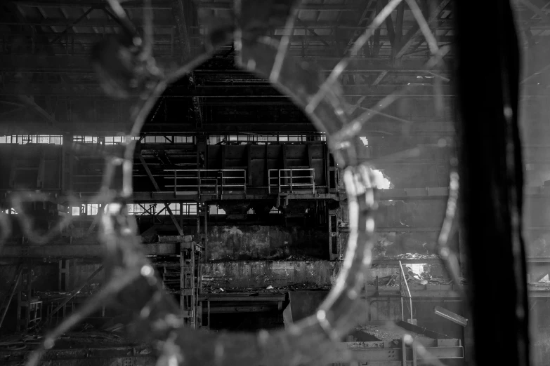 a view through the broken glass of a steel factory