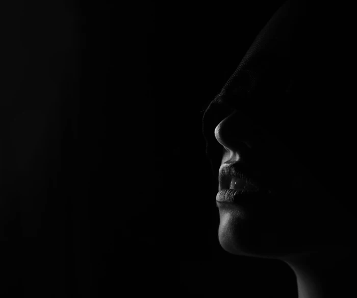 profile view of woman in silhouette, dark background