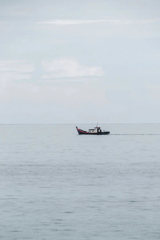 a single boat sitting in an open ocean