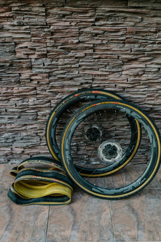 three tires are leaning against a brick wall