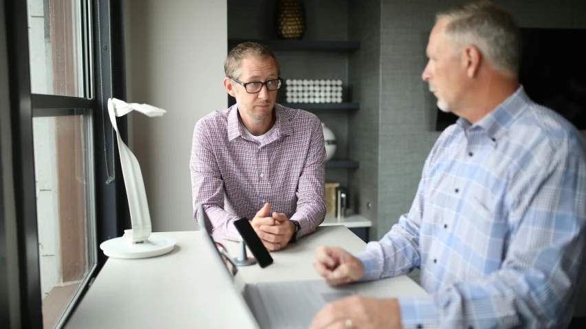 two people in front of a laptop at a desk