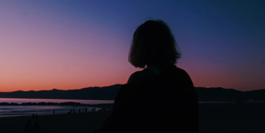 a person at the beach watching the sunset