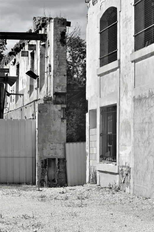 an empty fence in front of two white buildings