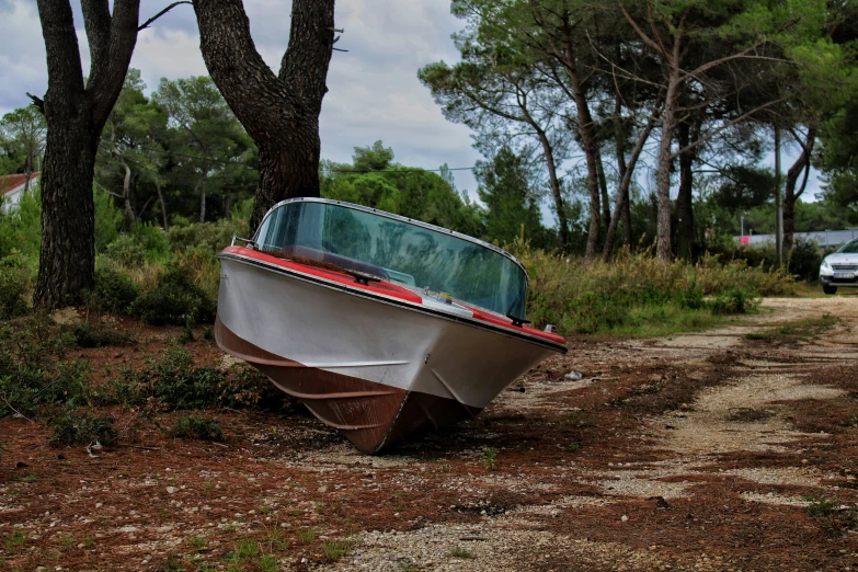 an upside down boat on land by some trees