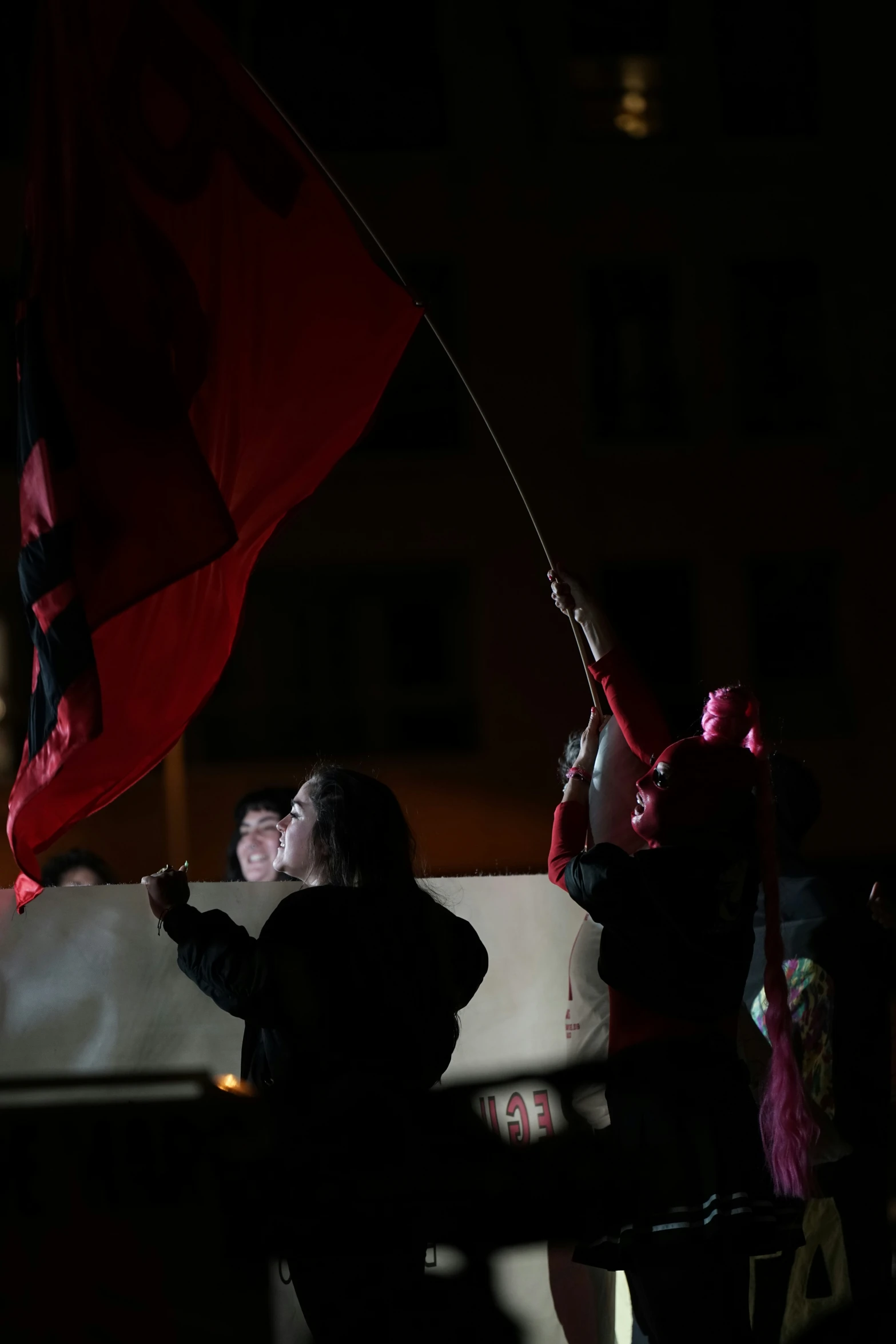 two people wave their national flags from a car during a parade