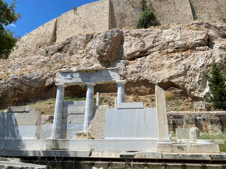 an old building is up against a mountain