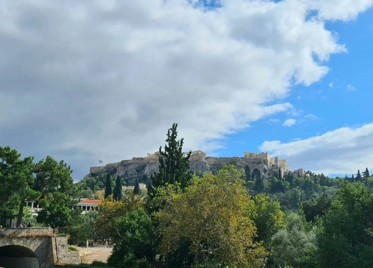 a view of some hills and buildings on a cloudy day