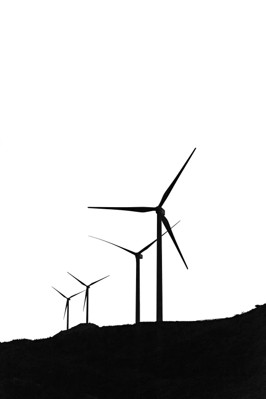 windmills silhouetted against a white, hazy sky