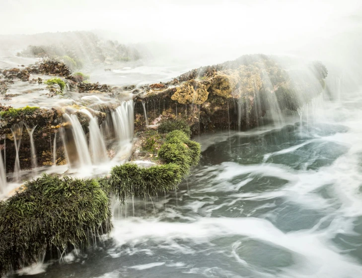 a very large waterfall is surrounded by water