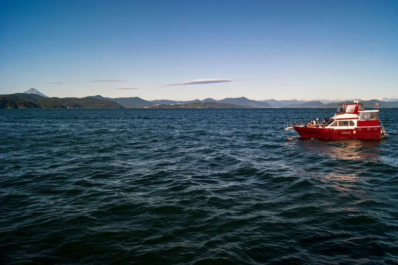 a big red boat in a big blue body of water