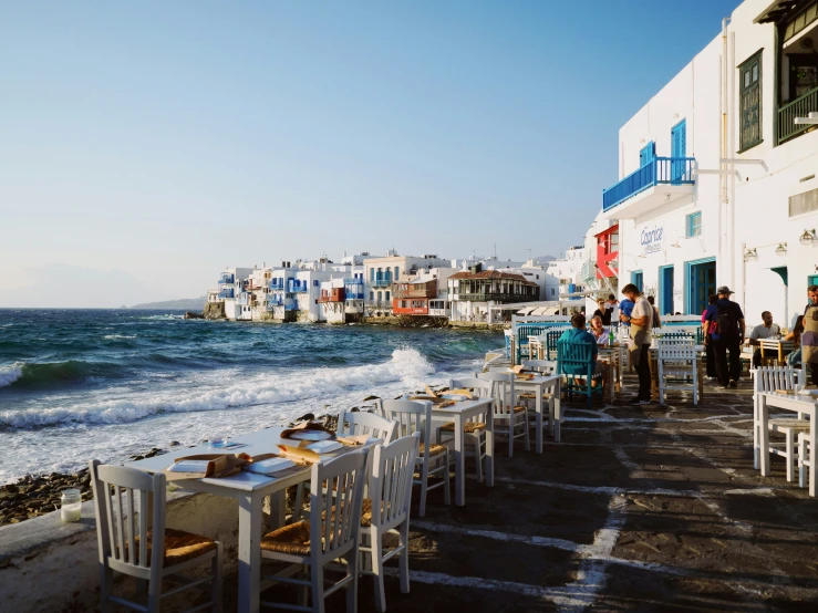 a beach with lots of chairs and white tables