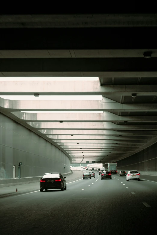 the underside of an overpass with cars driving on the road