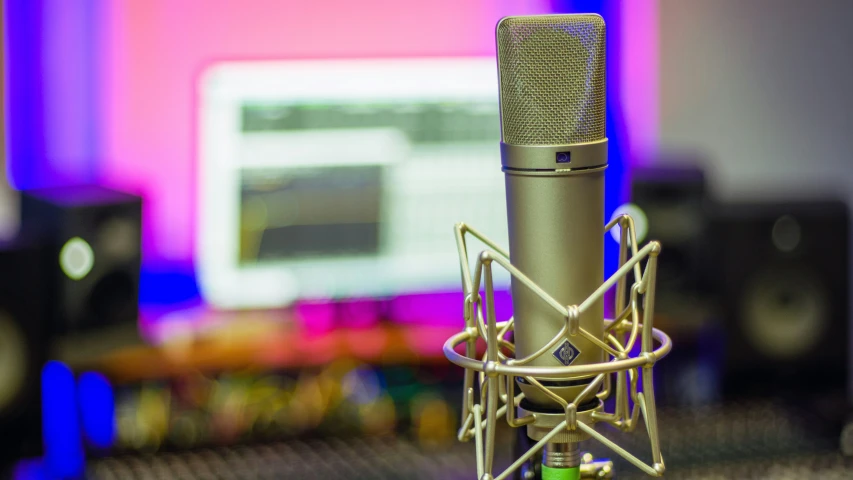 a microphone and computer screen with pink light