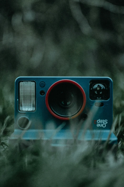 a small camera sitting in some green grass