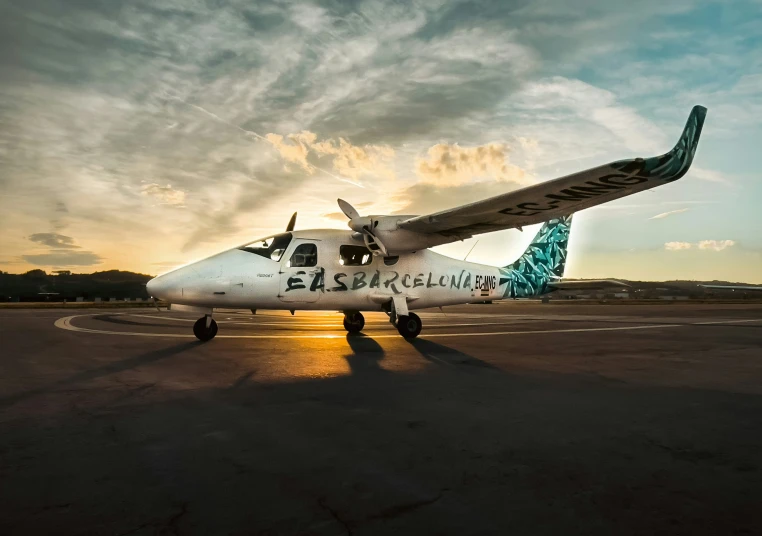 a plane sitting on an airport runway at sunset