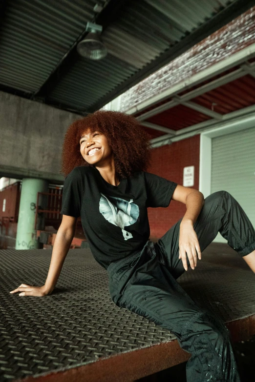 a black woman is smiling while sitting on a metal surface