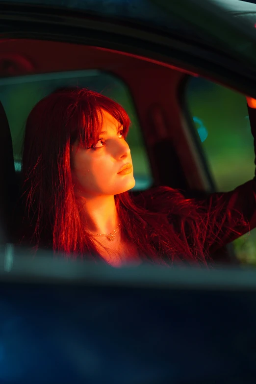 the woman's long red hair is shown from behind her wheel