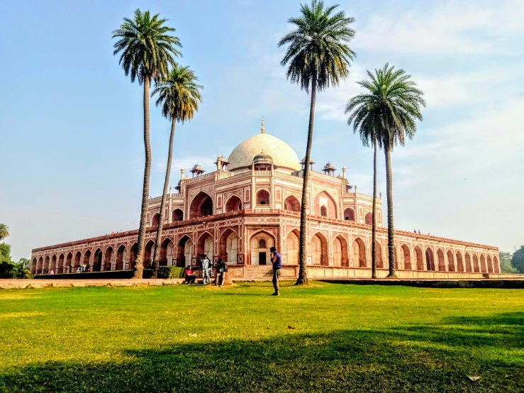 a large stone building sitting under palm trees