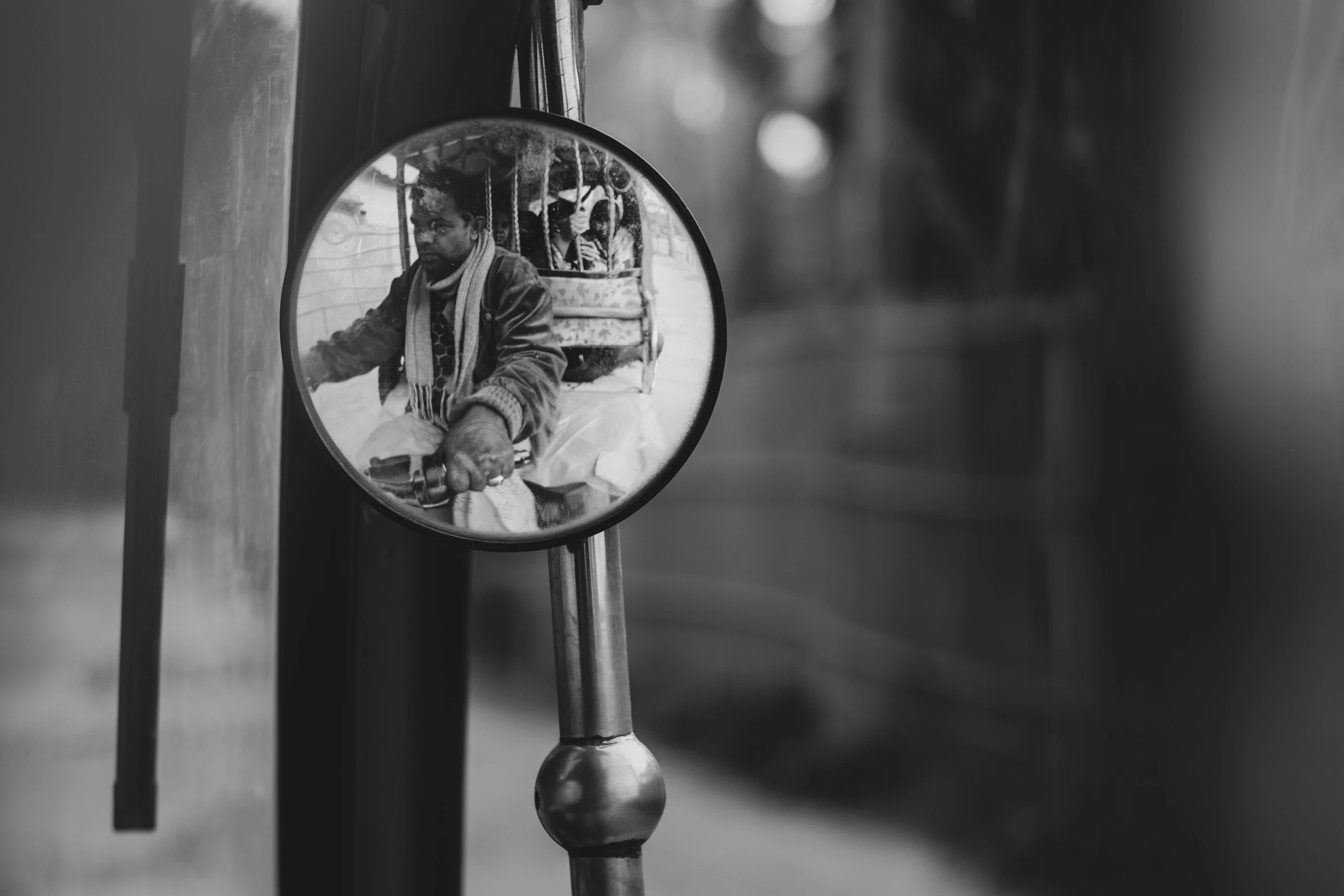 reflection of a man wearing a suit on a street pole