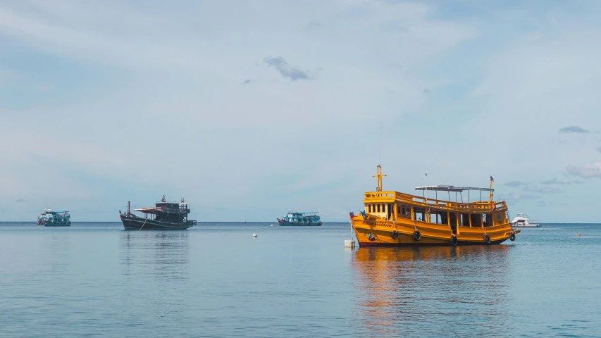 three ships are on a calm lake