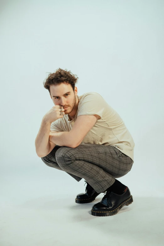 a man squatting in the snow and posing for a po