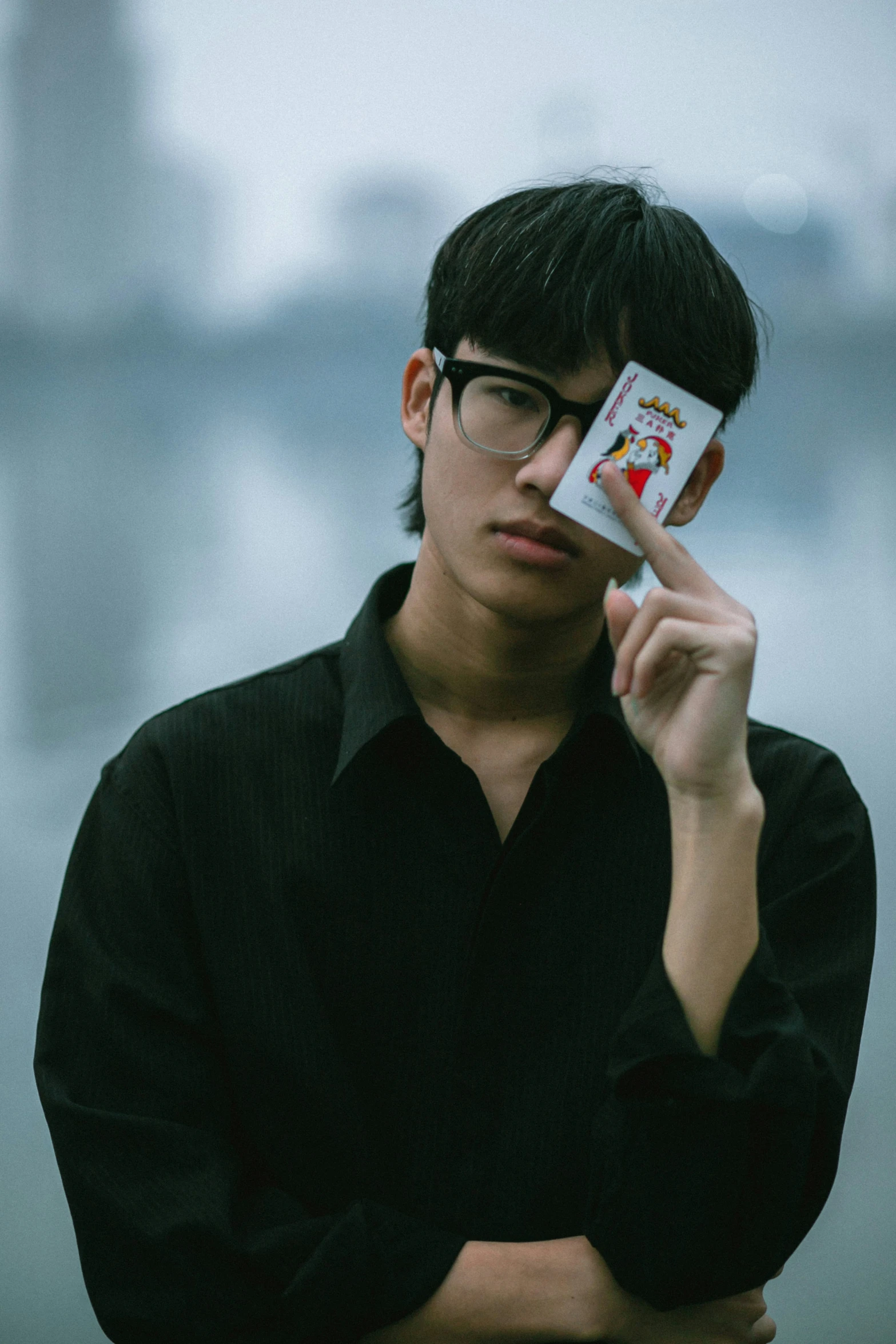 a man wearing glasses holding a small card