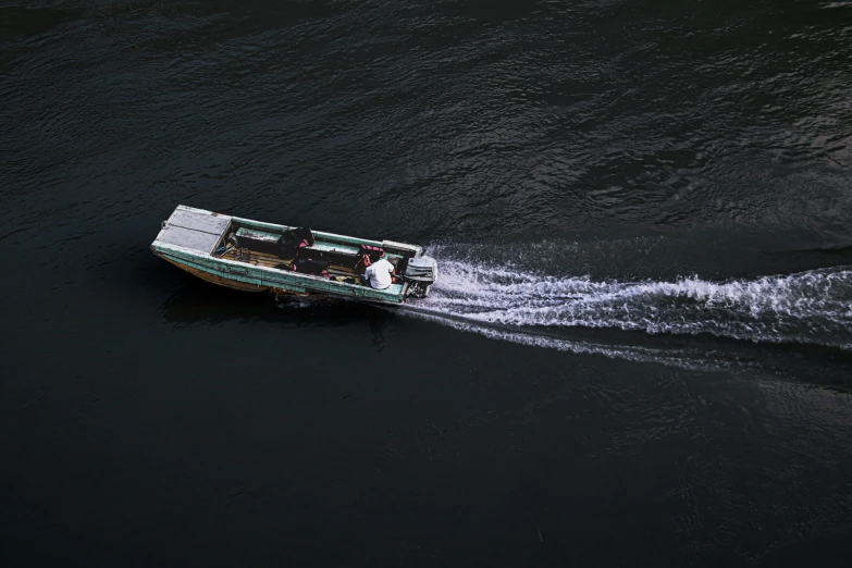 a small boat speeds along a large body of water