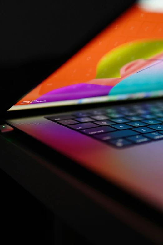 an apple laptop with a rainbow screen and keyboard