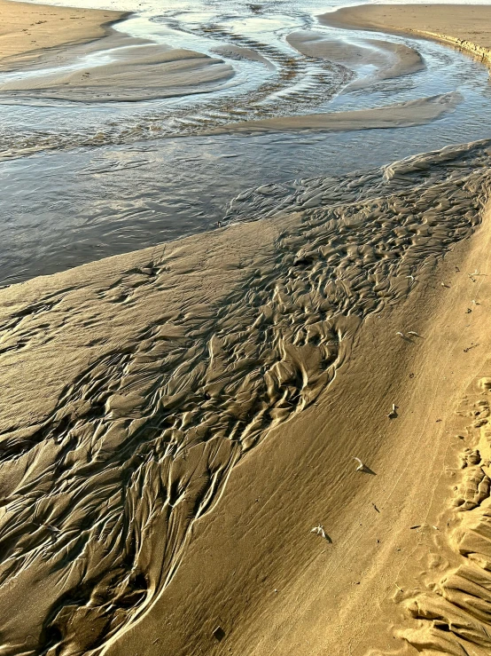 the waves in the sand are coming up onto the beach