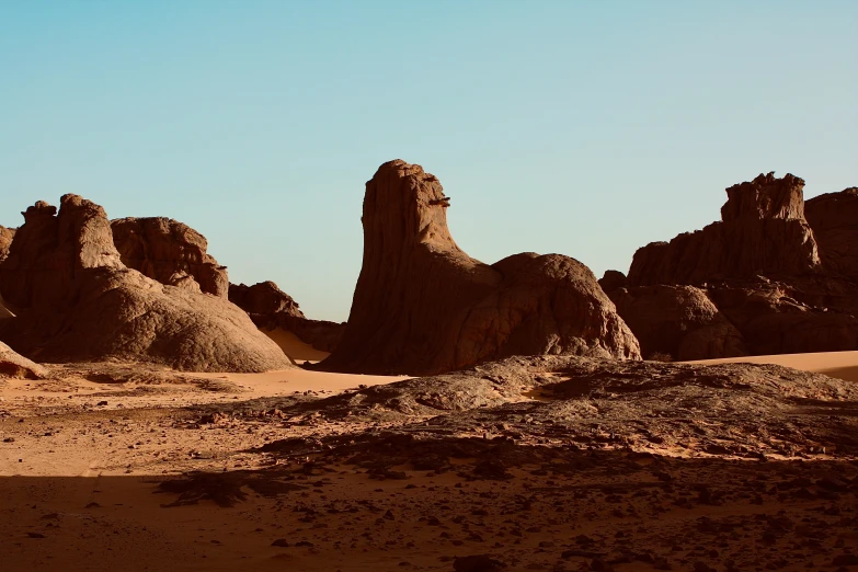 the desert has some sand dunes and large rocks