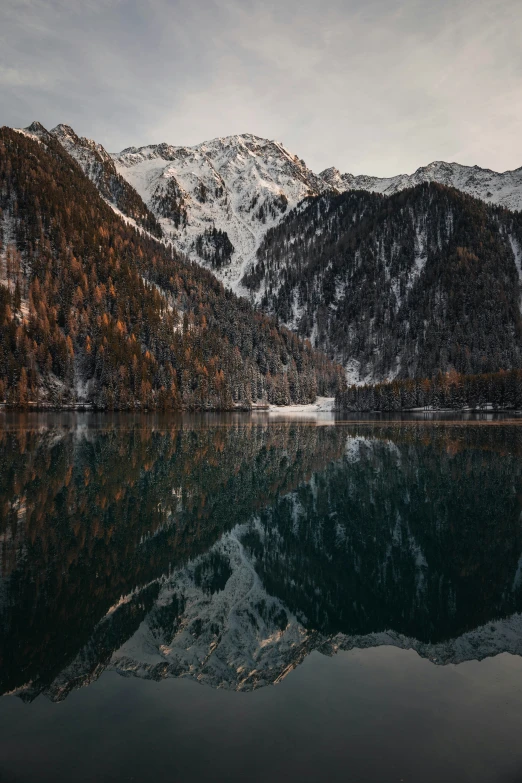 a mountain is in the distance while a body of water with trees along it