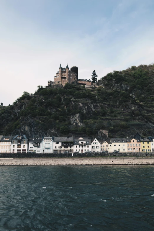 several buildings perched on top of a hill above the water