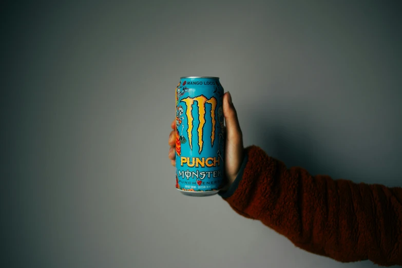 an orange shirt is holding up a blue can