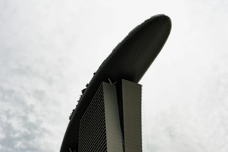 a large white curved building under a cloudy sky