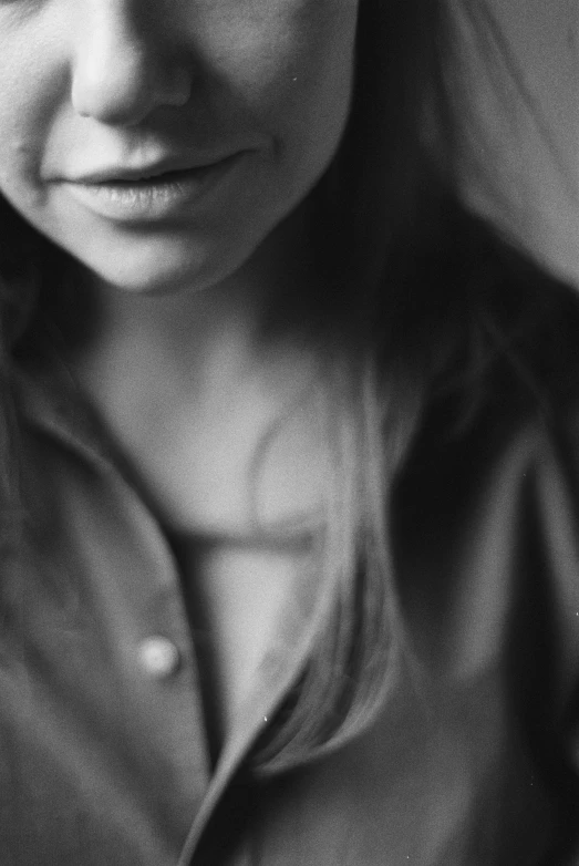 a woman in an unoned shirt looking off into the distance