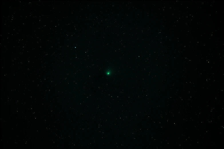 a very bright green object in the dark sky