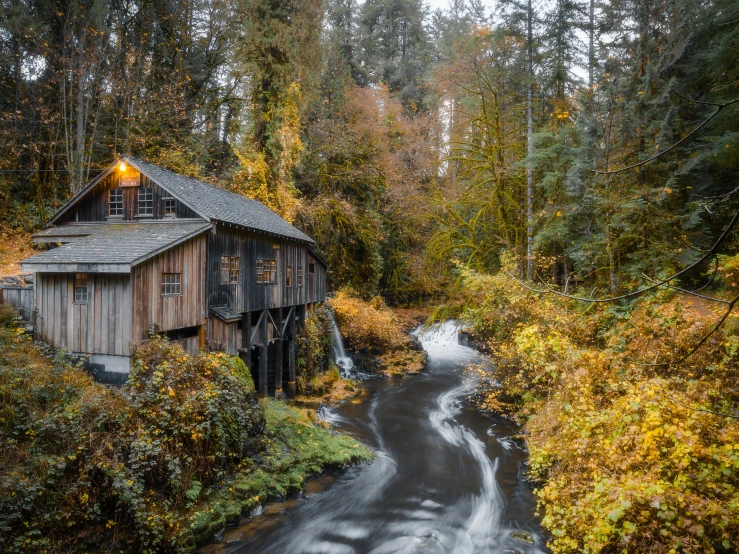 a barn sitting on top of a hillside near trees