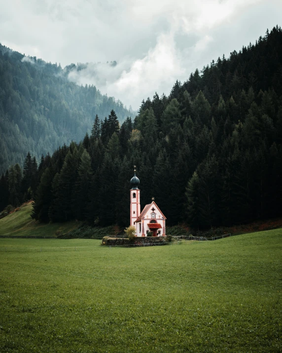 church standing in field with trees behind it