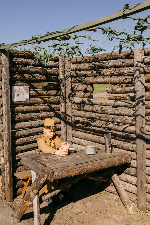 a wooden structure with logs and a person wearing sunglasses on their face