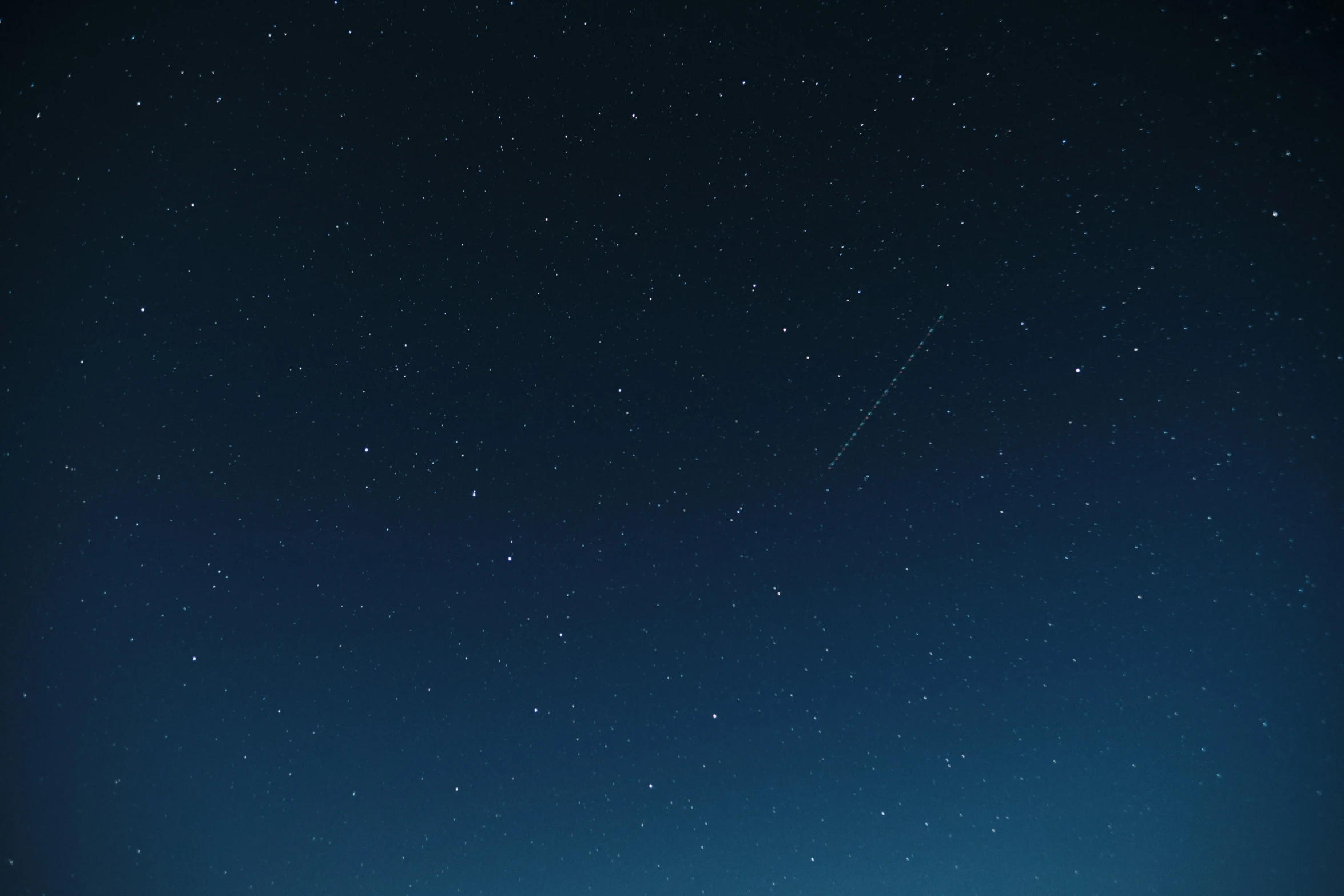 a man standing in a field under a night sky