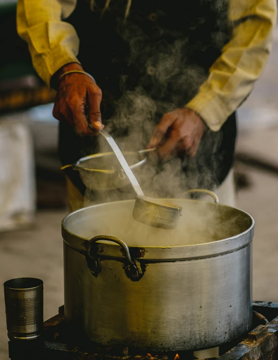 a person is stirring food into a pot