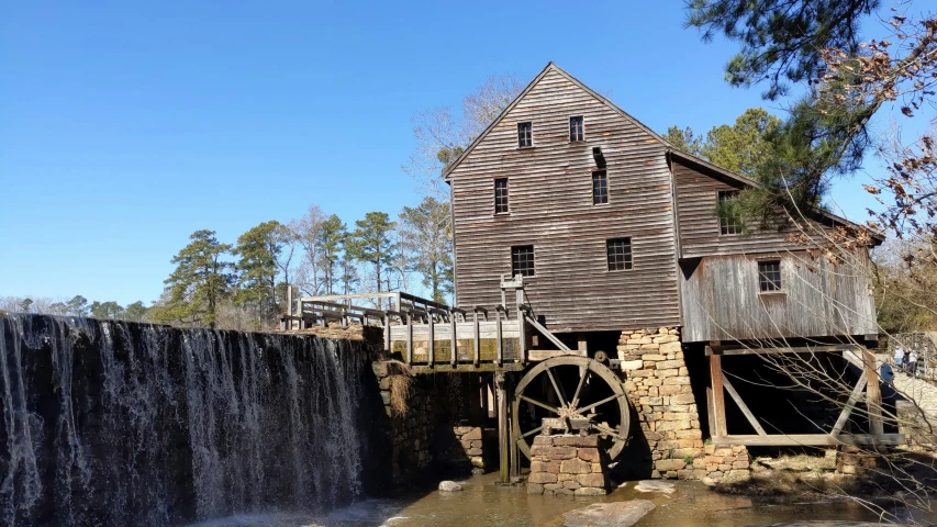 a wooden building sitting next to a waterfall