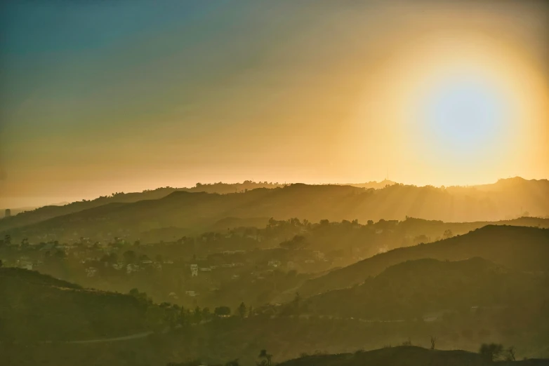 a bird flying above mountains during the sun