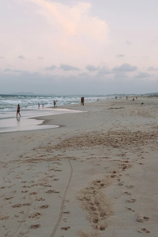 there are some people walking along the beach